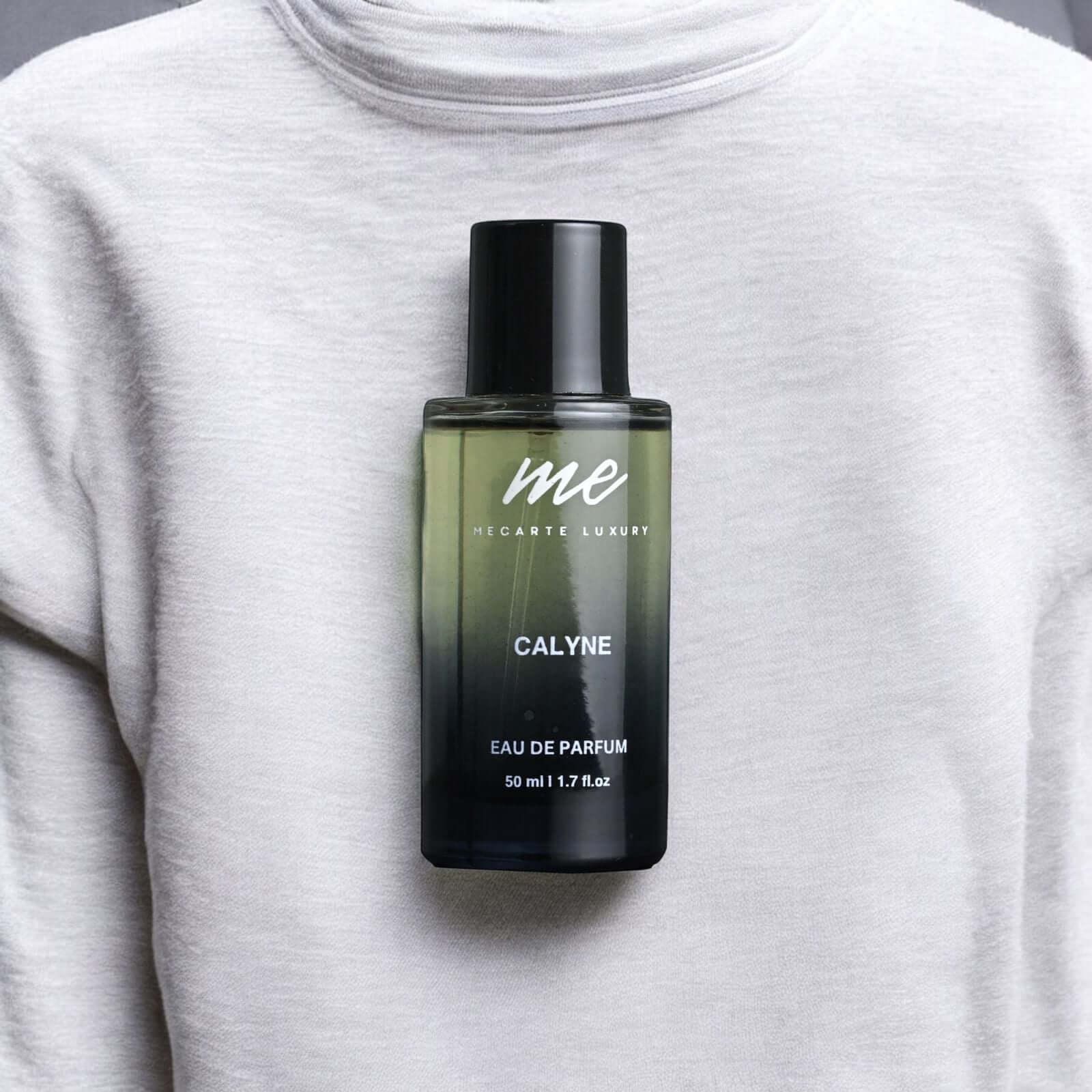 CALYNE, the best travel perfume India, displayed on a grey sweater, 50 ml Eau de Parfum bottle.